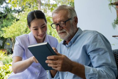 gülümseyen hemşire ile kıdemli adam mutluluk, b birlikte kitap okuyun