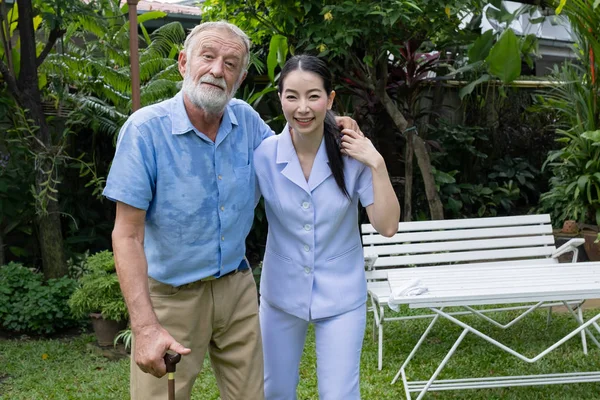 Senior man lycka och leende sjuksköterska, tar hand och discussio — Stockfoto