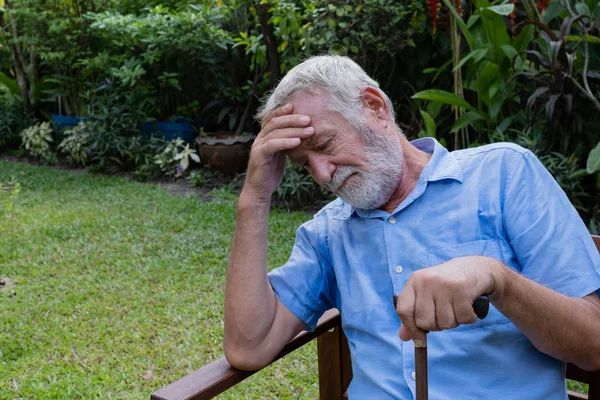 Uomo anziano seduto da solo nel giardino, e cercare di ricordare e — Foto Stock