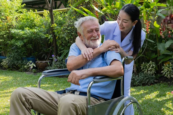 Senior Man boldogság ül tolószékben mosolygós nővér, t — Stock Fotó