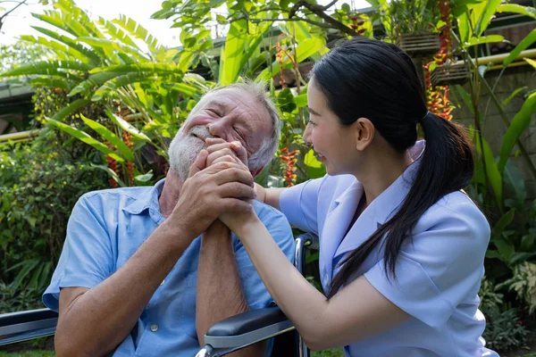 Senior Mann Glück sitzt im Rollstuhl mit lächelnder Krankenschwester, t — Stockfoto