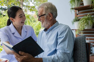 gülümseyen hemşire ile kıdemli adam mutluluk, b birlikte kitap okuyun
