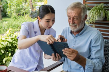 gülümseyen hemşire ile kıdemli adam mutluluk, b birlikte kitap okuyun