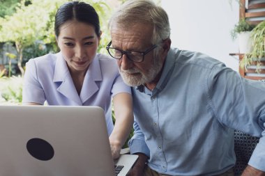 üst düzey adam ve hemşire, öğretim ve yakın balkonda dizüstü bilgisayar kullanarak 