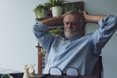 üst düzey adam mutluluk düşünme ve yakın balkonda satranç oynarken 