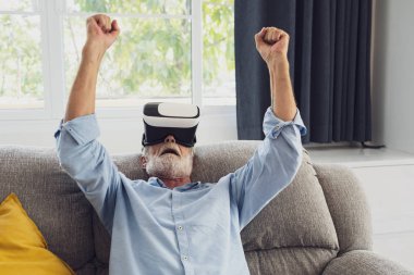 üst düzey adam mutluluk kanepede oturan ve V ile oyun oynarken