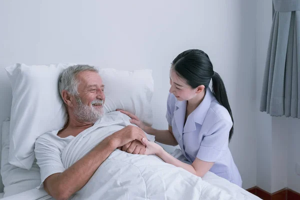 Anciano con enfermera sonriente, cuida y discute y —  Fotos de Stock