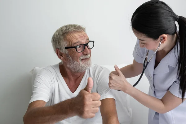 Homem idoso com enfermeira sorridente, cuida e debate após h — Fotografia de Stock