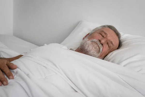 Anziano uomo dormire da solo sul letto in camera — Foto Stock