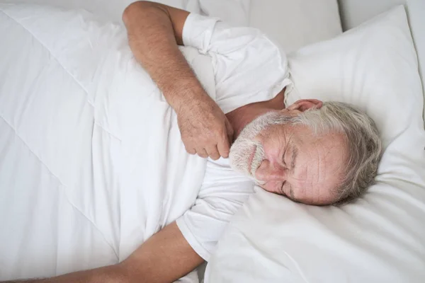 Hombre mayor durmiendo solo y dolor de cabeza o soñando pesadilla en — Foto de Stock
