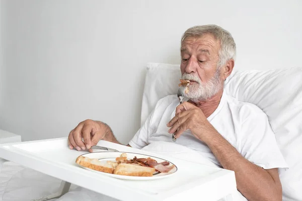 Senior man med leende sjuksköterska, tar hand frukost och mi — Stockfoto