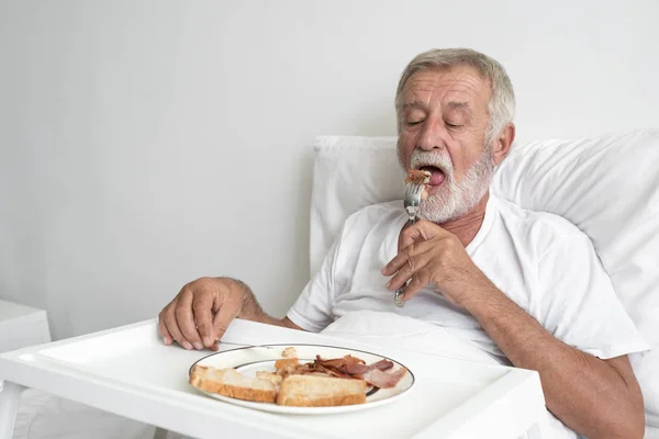 Senior man med leende sjuksköterska, tar hand frukost och mi — Stockfoto