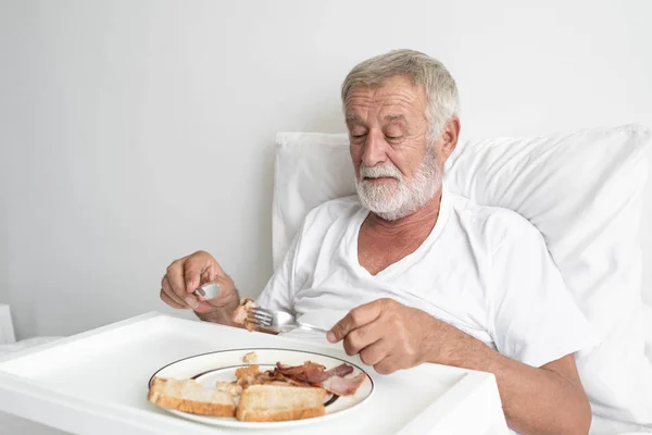 Starszy człowiek z uśmiechniętą pielęgniarką, dba o śniadanie i dyskutowanych — Zdjęcie stockowe
