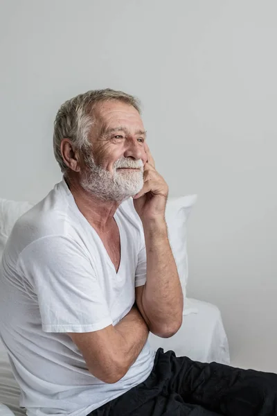 Hombre mayor pensando o tratar de recordar solo en la cama en roo blanco — Foto de Stock