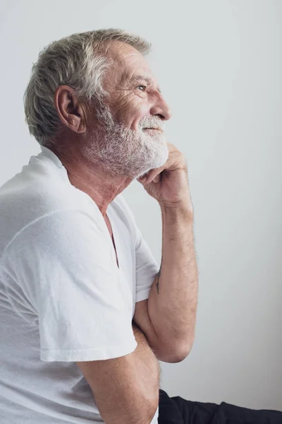Starszy człowiek myślący albo próbować wobec zapamiętać sam u łóżko w biały Roo — Zdjęcie stockowe