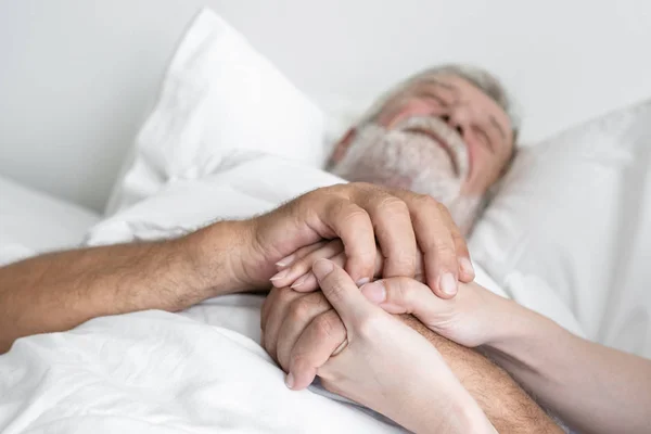 Ręka starszego mężczyzny z uśmiechniętą pielęgniarką, dba i rozwera się na b — Zdjęcie stockowe