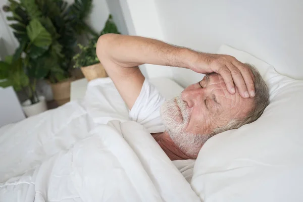 Senior man slaapt alleen en hoofdpijn of dromen nachtmerrie op Rechtenvrije Stockfoto's