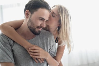 Aşk ta sevgi dolu mutlu çift gülümseme ve yatakta birbirlerine sarılmak,