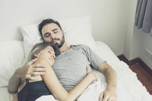 Kärleksfull lycklig par i kärlek leende och krama varandra på sängen, — Stockfoto