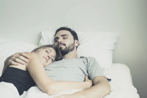 Loving happy couple in love smile and hug each other on the bed,