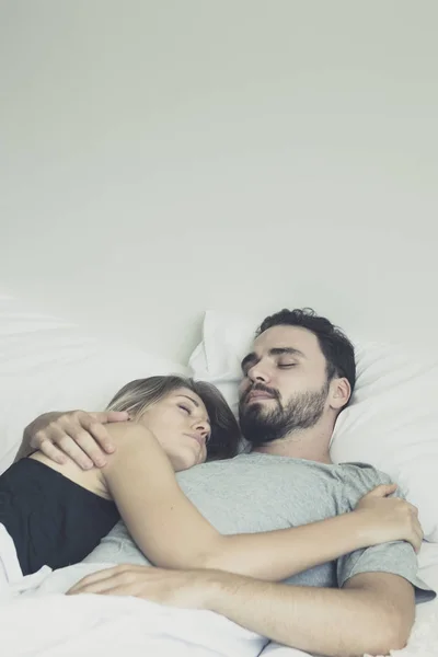 Liefdevolle gelukkig paar in liefde glimlach en knuffel elkaar op het bed, — Stockfoto