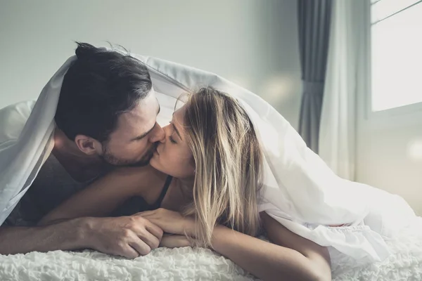 Loving happy couple in love smile and kiss each other under blan — Stock Photo, Image