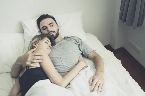 Liefdevolle gelukkig paar in liefde glimlach en knuffel elkaar op het bed, — Stockfoto