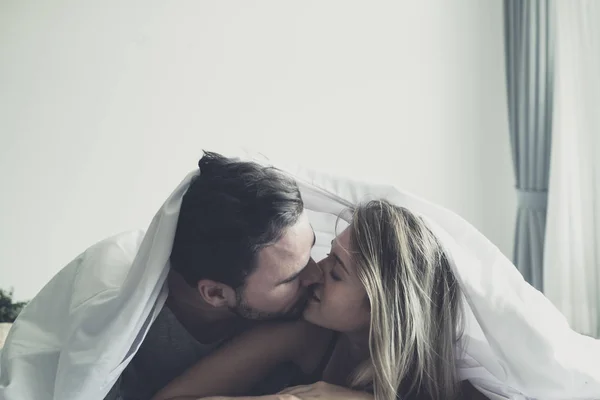 Amar feliz pareja en el amor sonrisa y besarse bajo blan Fotos de stock