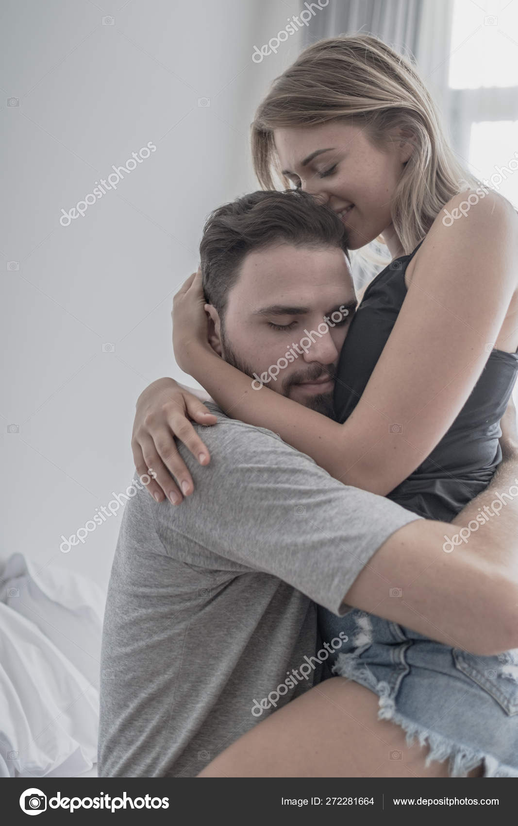 Loving happy couple in love smile and hug each other on the bed ...