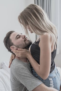 Aşk ta sevgi dolu mutlu çift gülümseme ve yatakta birbirlerine sarılmak,