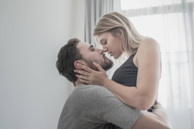 Aşk ta sevgi dolu mutlu çift gülümseme ve yatakta birbirlerine sarılmak,