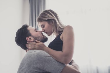 Aşk ta sevgi dolu mutlu çift gülümseme ve yatakta birbirlerine sarılmak,