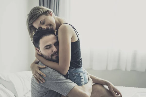 Liefdevolle gelukkig paar in liefde glimlach en knuffel elkaar op het bed, — Stockfoto