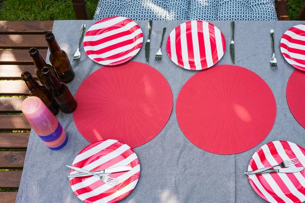 Sistemare tavolo di legno all'aperto e piatto rosso con birre per il cibo e — Foto Stock