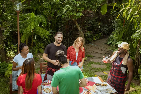 Grupo de amigos felizes de pé comendo e bebendo cervejas no bar — Fotografia de Stock