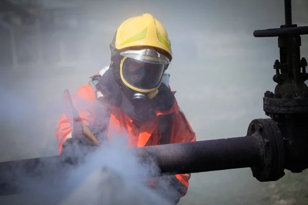 Pompier portant une combinaison de sécurité et marchant jusqu'à la zone endommagée par le feu — Photo