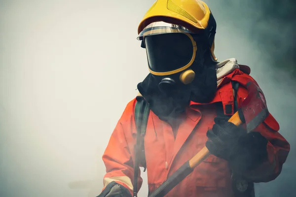 방호복을 입고 화재 피해 지역으로 걸어가는 소방관 — 스톡 사진