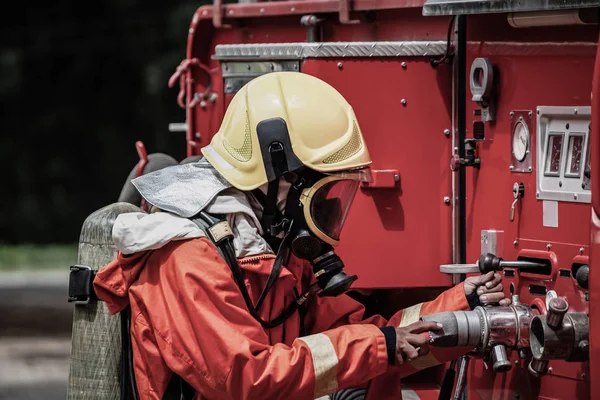 Firefighter wearing safety suite is using the high pressure wate — Stock Photo, Image