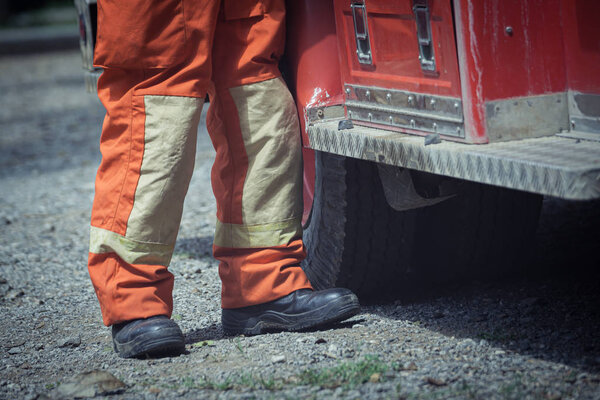 Safety shoes for Firefighter and safety suite stand near fire en