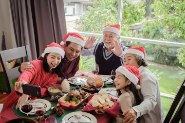 Noel 'de yemekten sonra büyük aile selfie' si çekilirken mutlu olurlar ve gülümserler. Asya aile tatili konsepti.