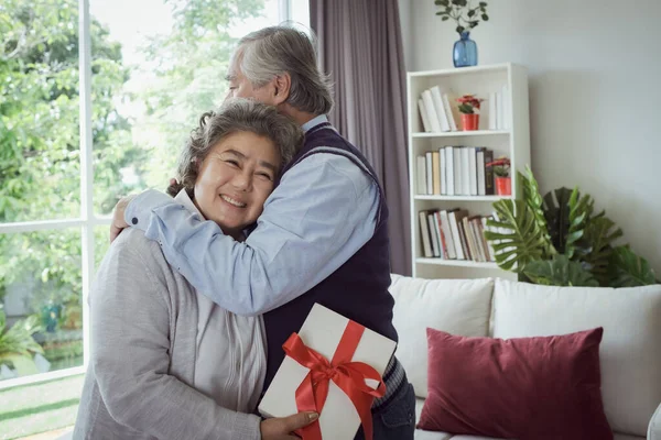 Gelukkig Paar Oude Oudere Senior Man Vrouw Knuffelen Houden Geschenkdoos — Stockfoto