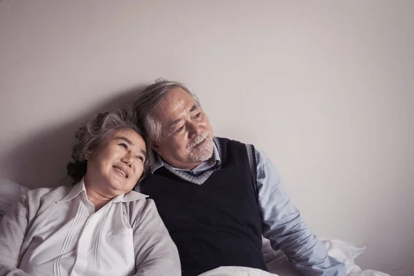 高齢者カップルCaucasianシニア男性と女性に座っているベッドルームで白い毛布で一緒に窓の外を見ます 愛のライフスタイルの概念と退職医療 — ストック写真