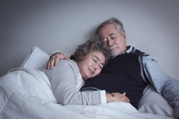 高齢者カップルCaucasianシニア男性と女性の睡眠と一緒にベッドルームで白い毛布で休みます 愛のライフスタイルのコンセプトと退職医療 — ストック写真