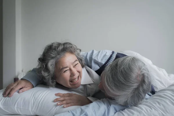 高齢者カップルCaucasianシニア男性と女性はベッドの上で寝るとベッドルームで白い毛布で笑顔 愛のライフスタイルの概念と退職医療 — ストック写真