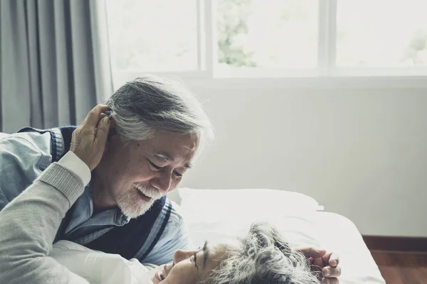 上了年纪的夫妻白种人可爱的老年男女睡在床上 在卧室里笑着 退休后的医疗保健与爱情生活方式的概念 — 图库照片