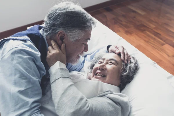 上了年纪的夫妻白种人可爱的老年男女睡在床上 在卧室里笑着 退休后的医疗保健与爱情生活方式的概念 — 图库照片