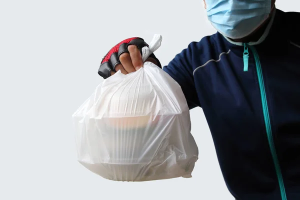 Gıda hizmeti sağlayıcıları maske takar. Beyaz arka planda izole edilmiş gıda siparişi veren müşterilere plastik poşetler yollamak Güneydoğu Asya 'daki Covid-19 virüsü döneminde çok popülerdi..