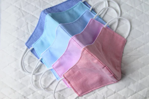 Pastel renk kumaş maske Beyaz kağıt üzerinde yer. Hava kirliliğini ve virüsleri önlemek için el işi kumaş maskeler..