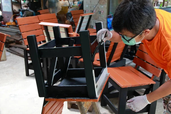 Working people painted chair legs to decorate it beautifully.Household business in the repair of wooden furniture.