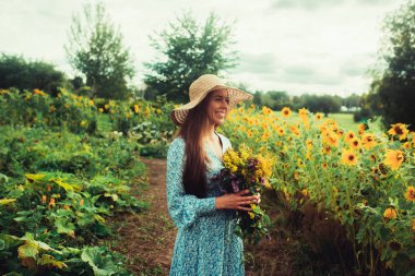 Ayçiçekleri arasında tarlada yürüyün